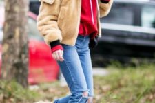 With red sweatshirt, distressed jeans and two color boots