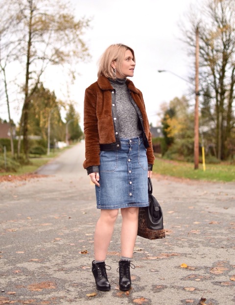 With turtleneck, denim skirt, ankle boots and two color bag