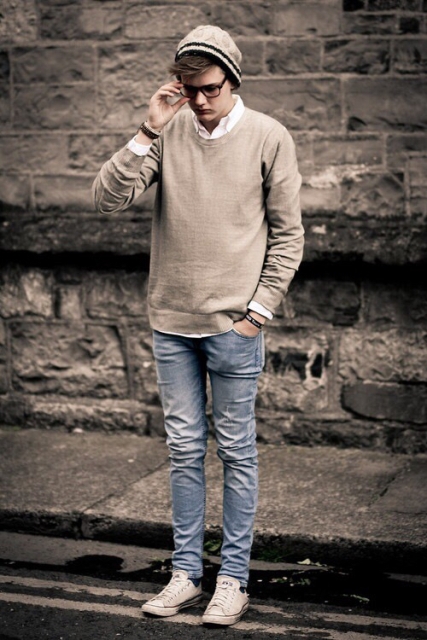 With white shirt, beige sweater, jeans and sneakers