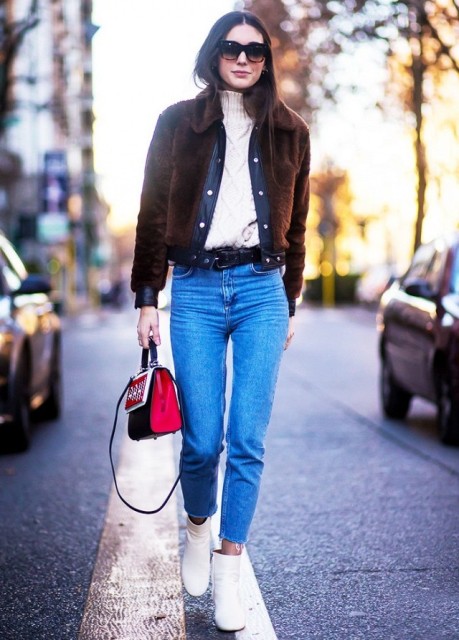 With white turtleneck, crop jeans, white ankle boots and black and red bag