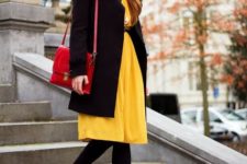 With yellow knee-length dress, black coat, black tights, ankle boots and red bag
