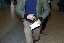 02 a navy sweater, neutral pants, a green puffer jacket, shoes and a beanie