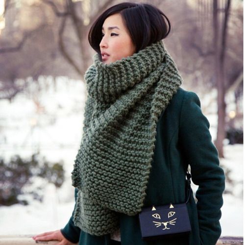 an olive green chuky knit scarf over an emerald coat for a holiday feel