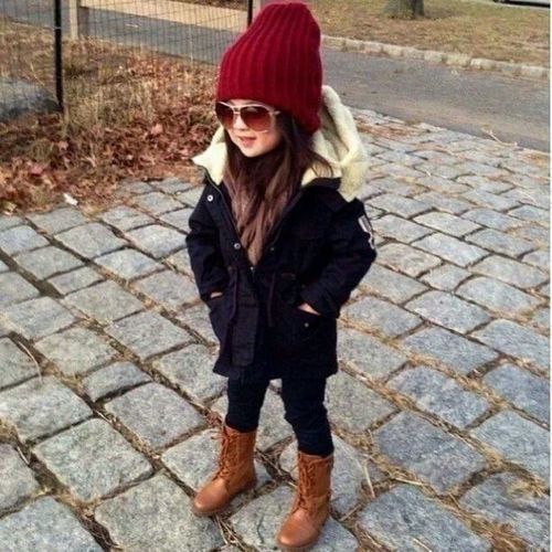 a black parka with white faux fur looks super chic with a red beanie