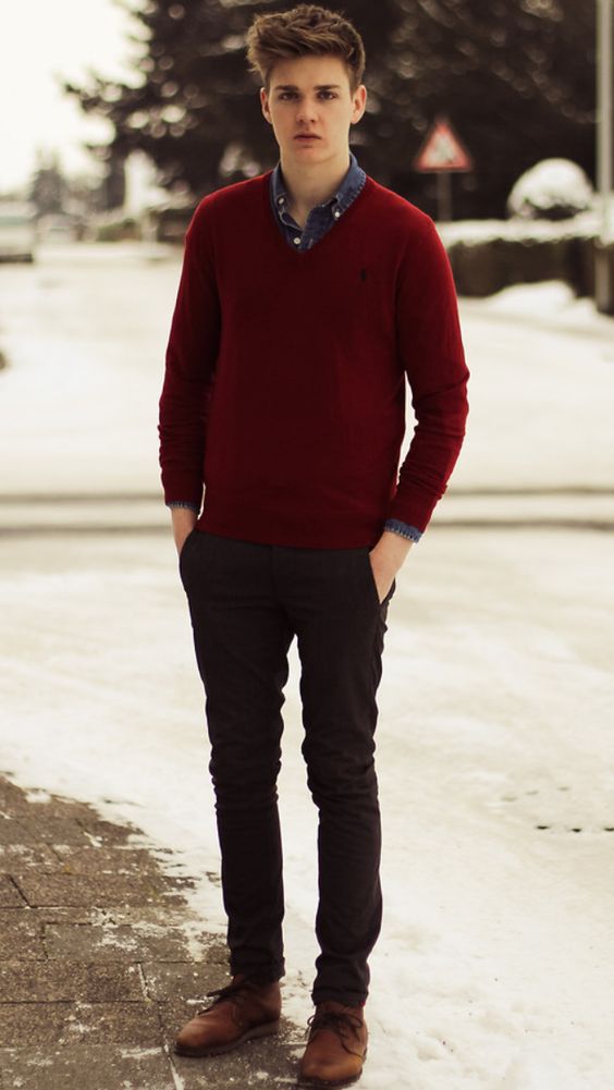 black pants, a denim shirt, a red sweater over it and brown shoes for an effortlessly chic look