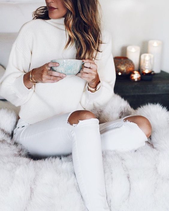 ripped jeans, a white sweater and some white and gold accessories