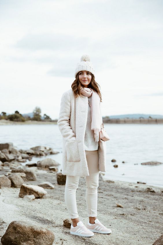 white jeans, a white sweater, coat and a beanie and a blush scarf and sneakers