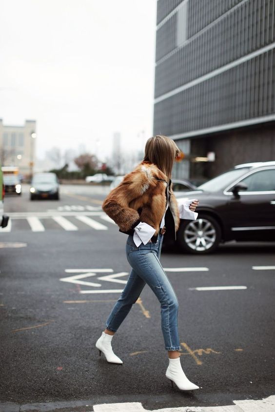 a white shirt, a black jacket, a faux fur coat, cropped jeans and white sock boots with kitten heels