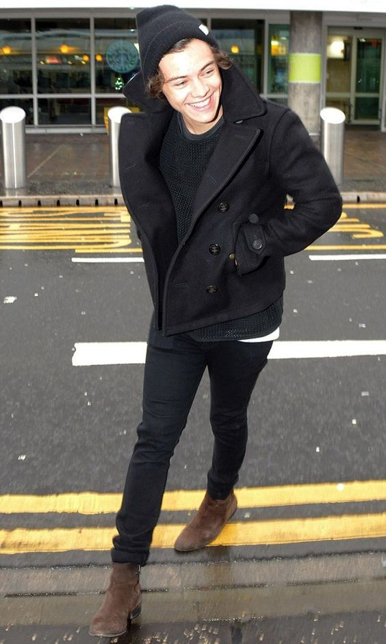 brown boots, a black sweater, black jeans, a black short coat and a beanie