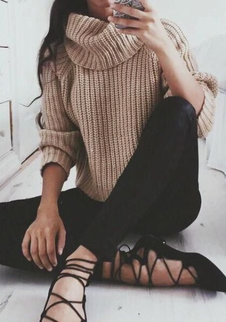 a beige chunky knit sweater, black jeans and black lace up shoes