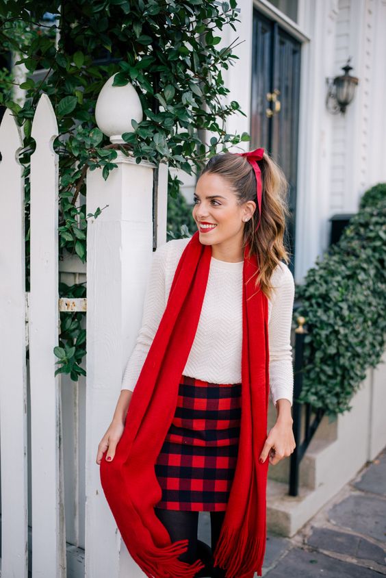 a white long sleeve top, a plaid mini, black tights and a red scarf