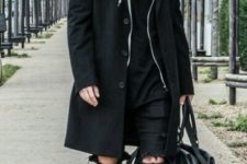 Black hoodie, knee-length coat, distressed pants, suede boots and bag