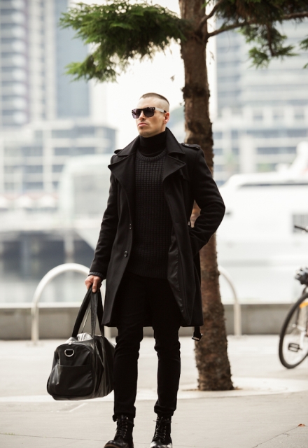Timeless all-black men outfit with a black trench coat with turtleneck, straight pants, mid calf boots and tote