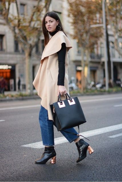 With black turtleneck, black boots with metallic heels, tote and beige cape