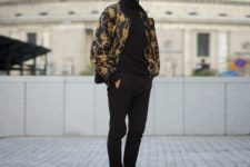 With black turtleneck, pants, boots and printed jacket