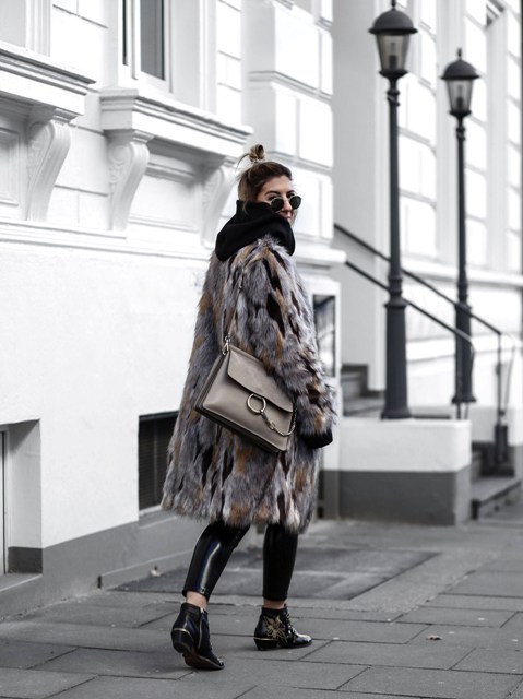 With fur coat, flat boots and gray bag