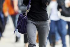 With gray jeans, black shirt and purple bag