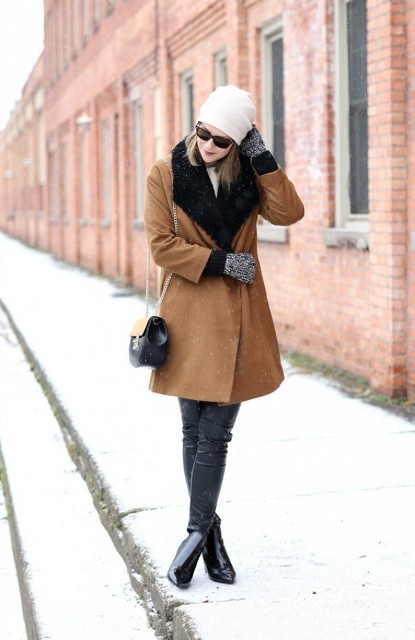 With leather pants, brown coat with fur collar, white beanie and chain strap bag