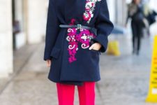 With navy blue coat, belt and hot pink trousers