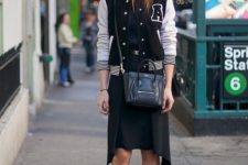 With navy blue shirt, knee-length skirt, ankle boots and bag