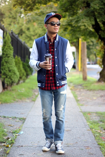 With plaid shirt, distressed jeans, cap and sneakers