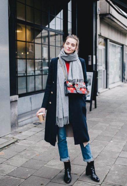 With red shirt, cuffed jeans, navy blue midi coat, gray scarf and printed bag