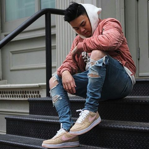 With white hoodie, distressed jeans and beige sneakers