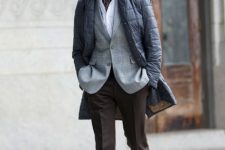 With white shirt, printed blazer, puffer coat, brown trousers and leather boots