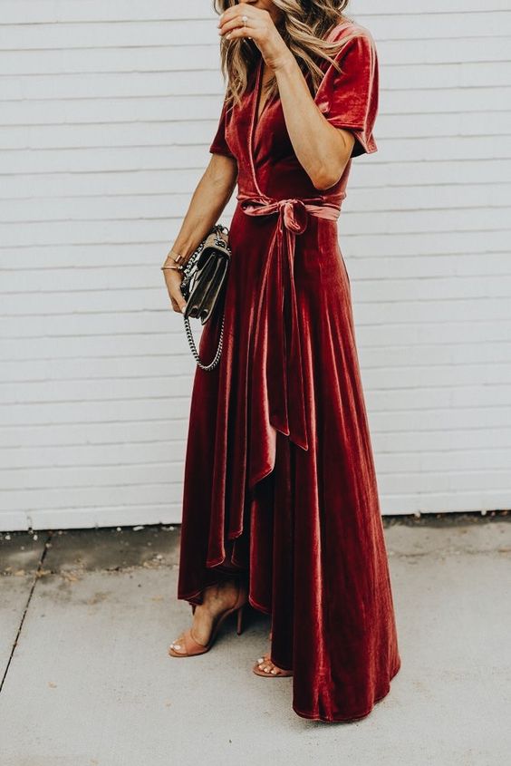 A red velvet wrap dress with a high low skirt and a V neckline plus short sleeves