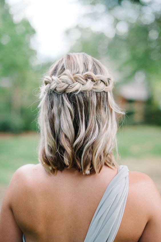 a messy half updo with a large braid and balayage is a chic idea