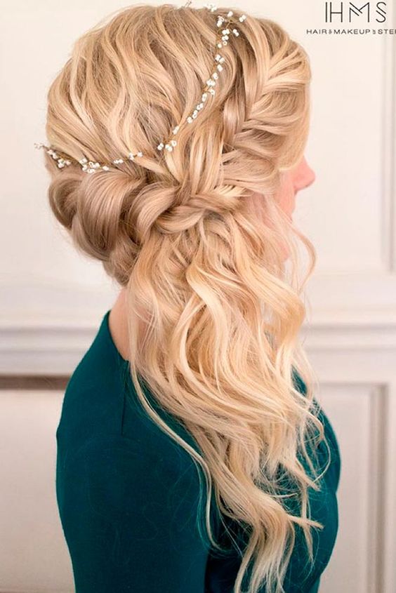 a side braided half updo accessorized with a small flower branch