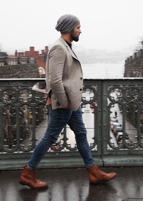 blue jeans, brown boots, a neutral blazer, a grey beanie for a casual look
