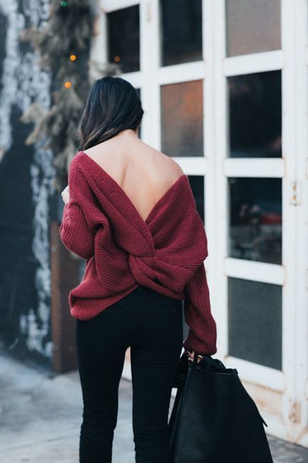 black jeans, a maroon cutout back sweater with a knot