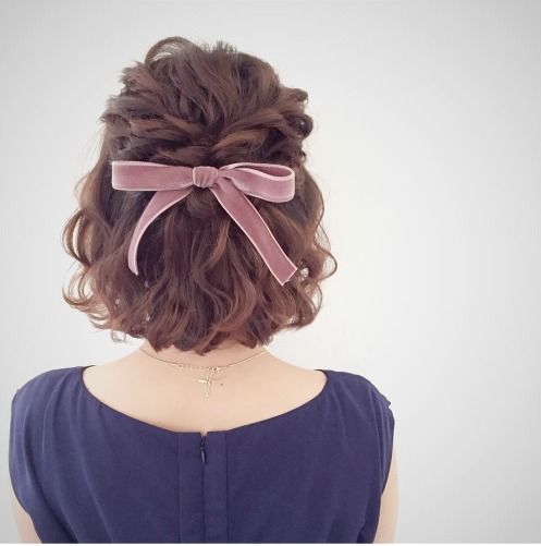 wavy short hair with a twisted braid and a pink velvet bow