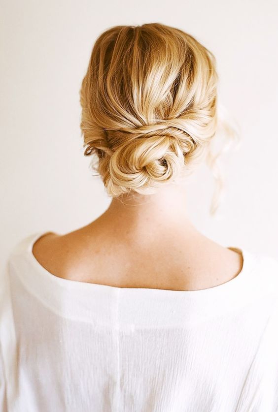 a messy, wavy twsited low bun with all hair up
