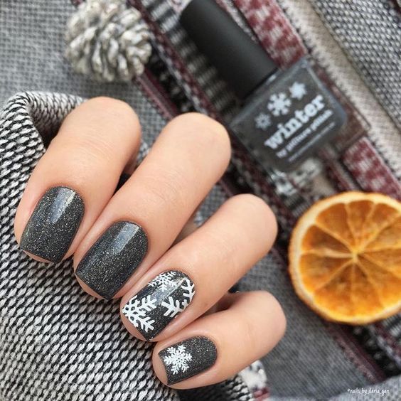 black glitter nails with some snowflakes look very chic