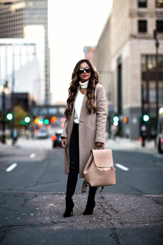 black ripped jeans, a creamy cutout sweater, a blush coat and black boots