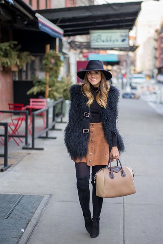 tall suede boots, a rust mini skirt, a faux fur vest and a black turtleneck