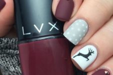 19 matte burgundy manicure with a grey polka dot and a white deer nail