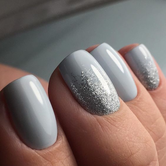 white nails with a touch of silver glitter for a chic wintery look