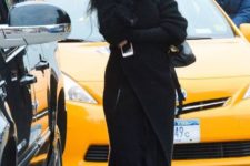 With black pants, maxi coat and gray shoes