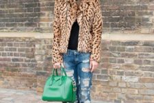 With black shirt, distressed jeans, leopard printed boots and green bag