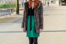 With black shirt, green skirt and black leather boots