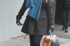 With dark gray coat, blue scarf, black tights and leather bag