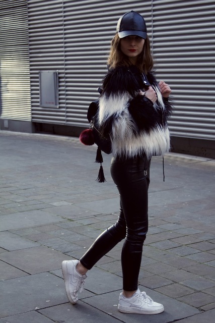 With fur jacket, leather pants, white sneakers and backpack