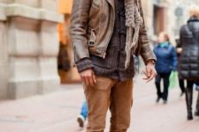 With gray cardigan, leather jacket, oversized scarf and brown pants