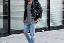 With gray shirt, black leather jacket, distressed jeans and white sneakers
