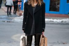 With gray sweater, black coat, leather pants and lace up boots
