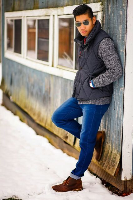 With gray sweater, black puffer vest and cuffed jeans