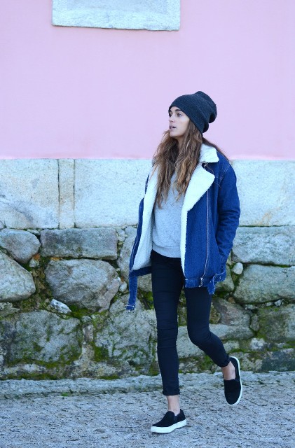 With gray sweatshirt, crop jeans, black shoes and navy blue beanie